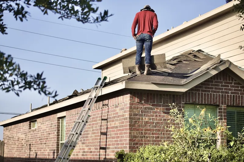 Professional roofer working on a residential roof in Torrington